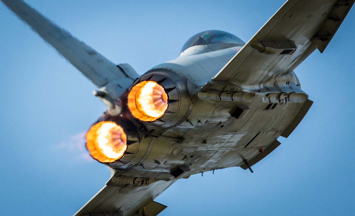 The back of a fighter jet showing red hot jets